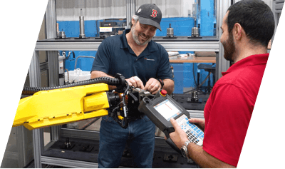 Two technicians adjusting a machine.