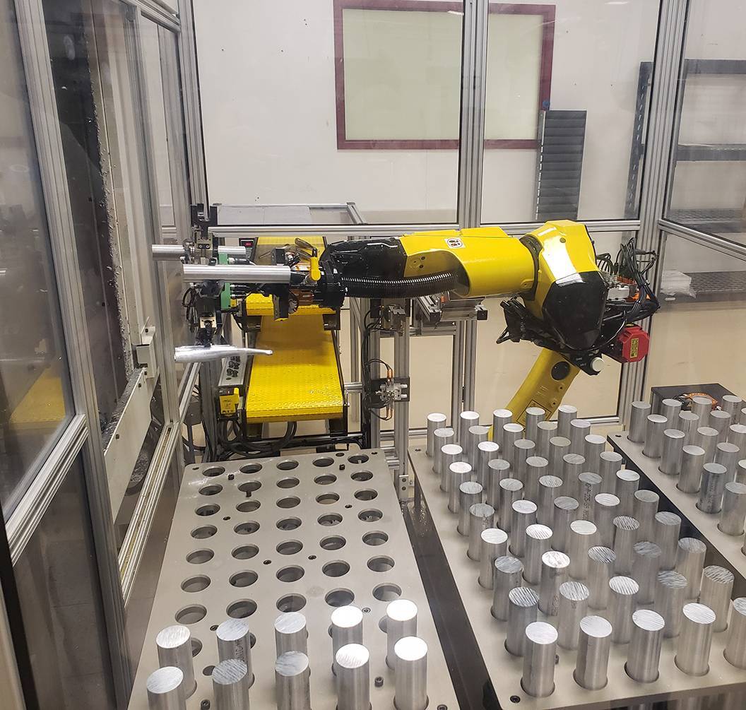 Industrial robot loading parts in automated CNC machining cell
