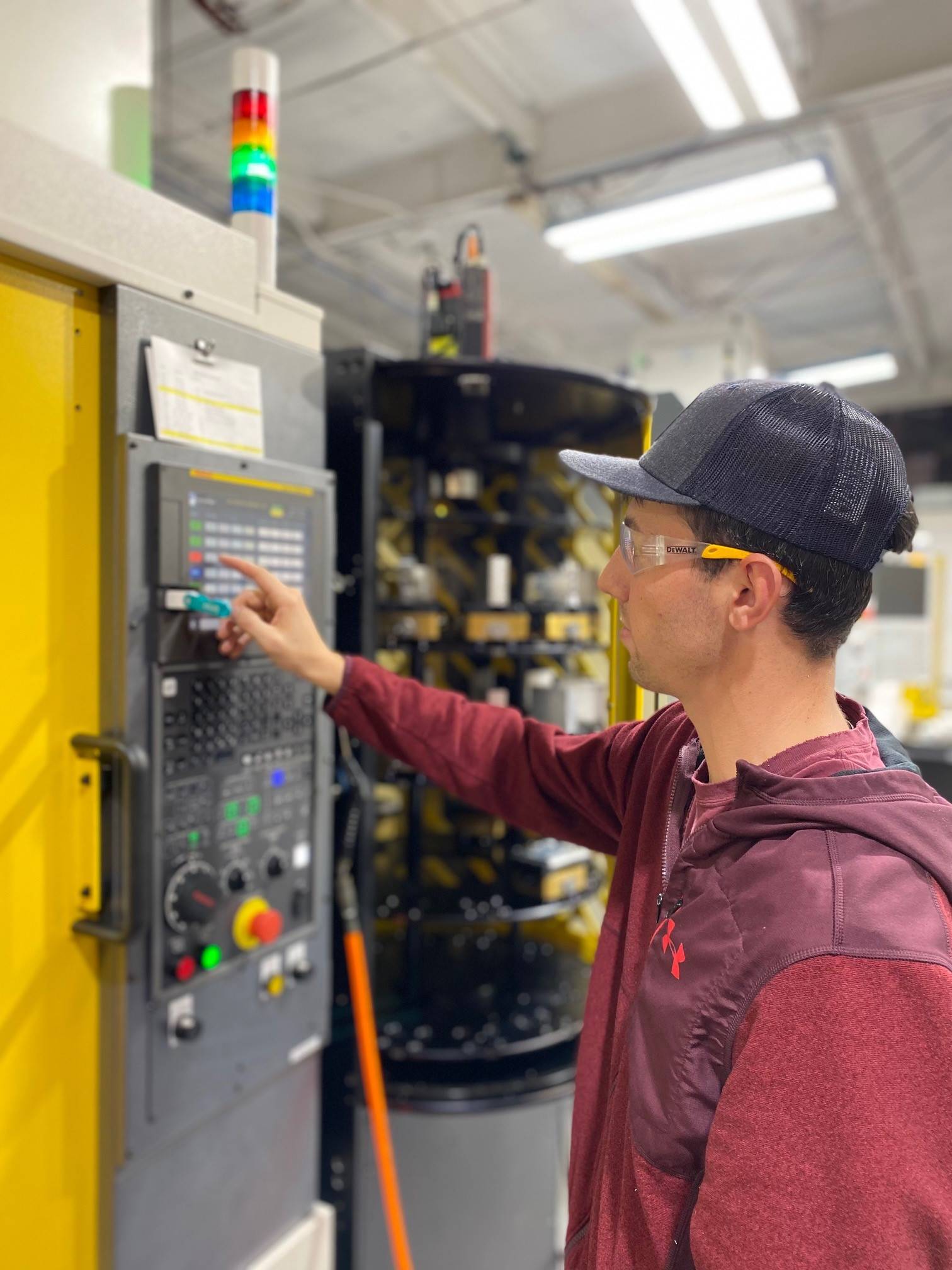 CNC machine operator managing automated precision manufacturing equipment