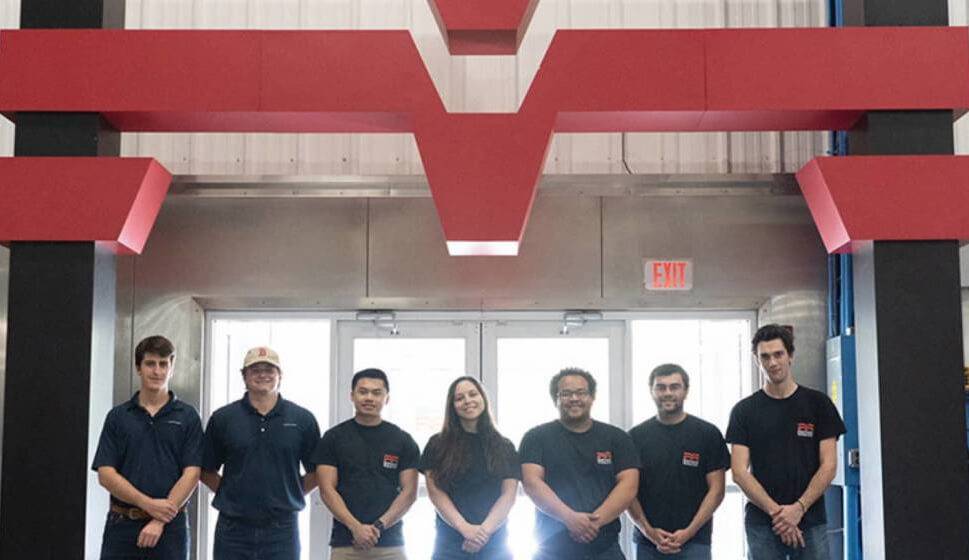 Methods employees posing for photo beneath the Methods logo