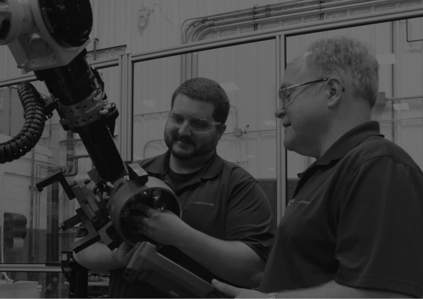Two Methods employees working on an automated machine setup