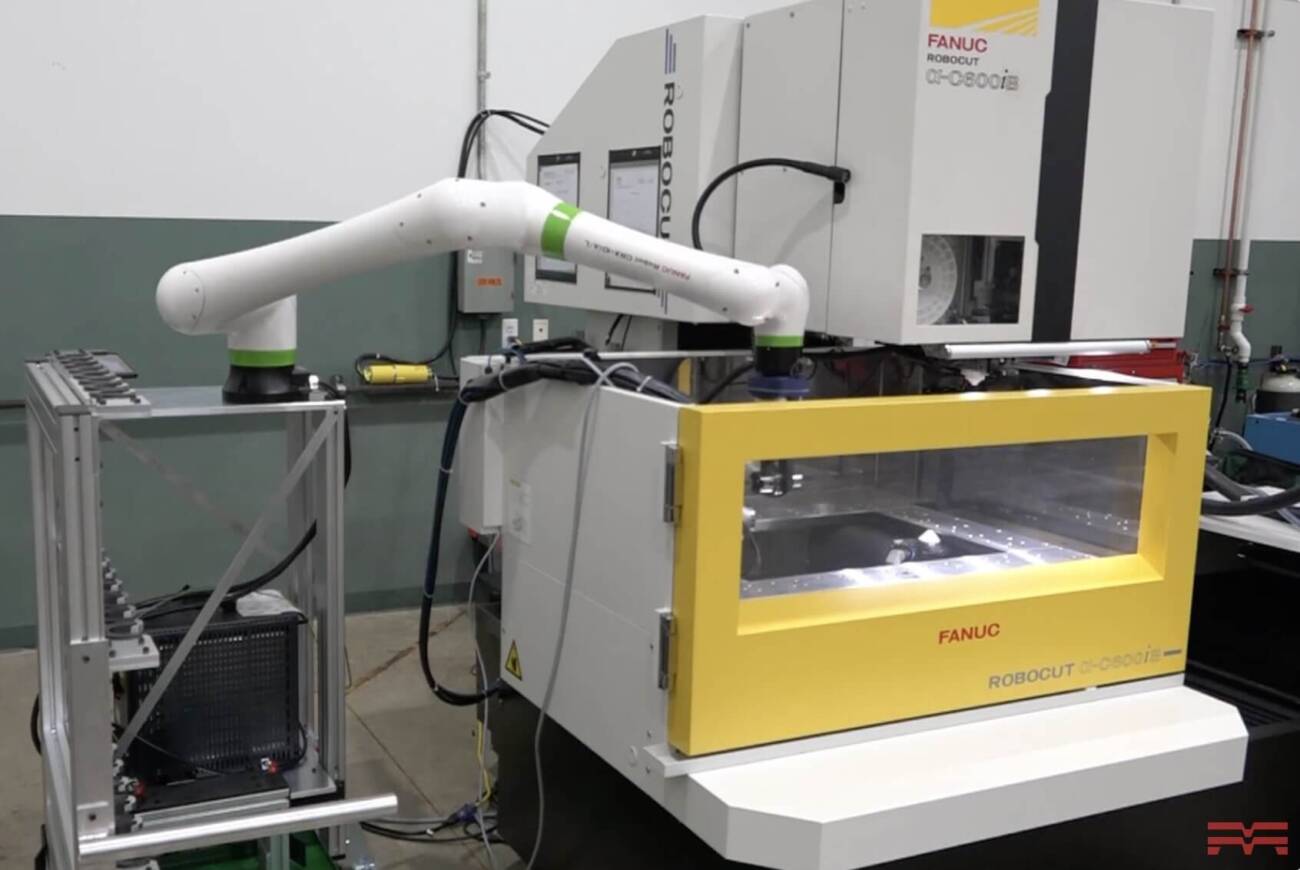 an automated FANUC CRX cobot arm removing a workpiece from the chamber of a FANUC ROBOCUT wire EDM machine tool